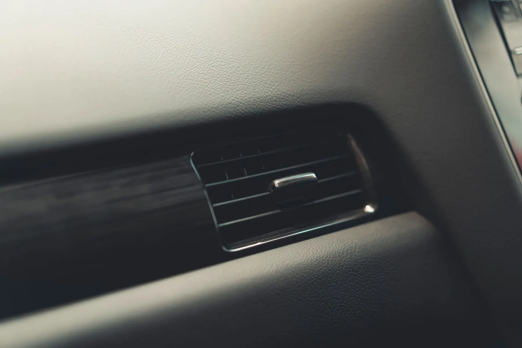 Air conditioning service gauges connected to a vehicle engine bay