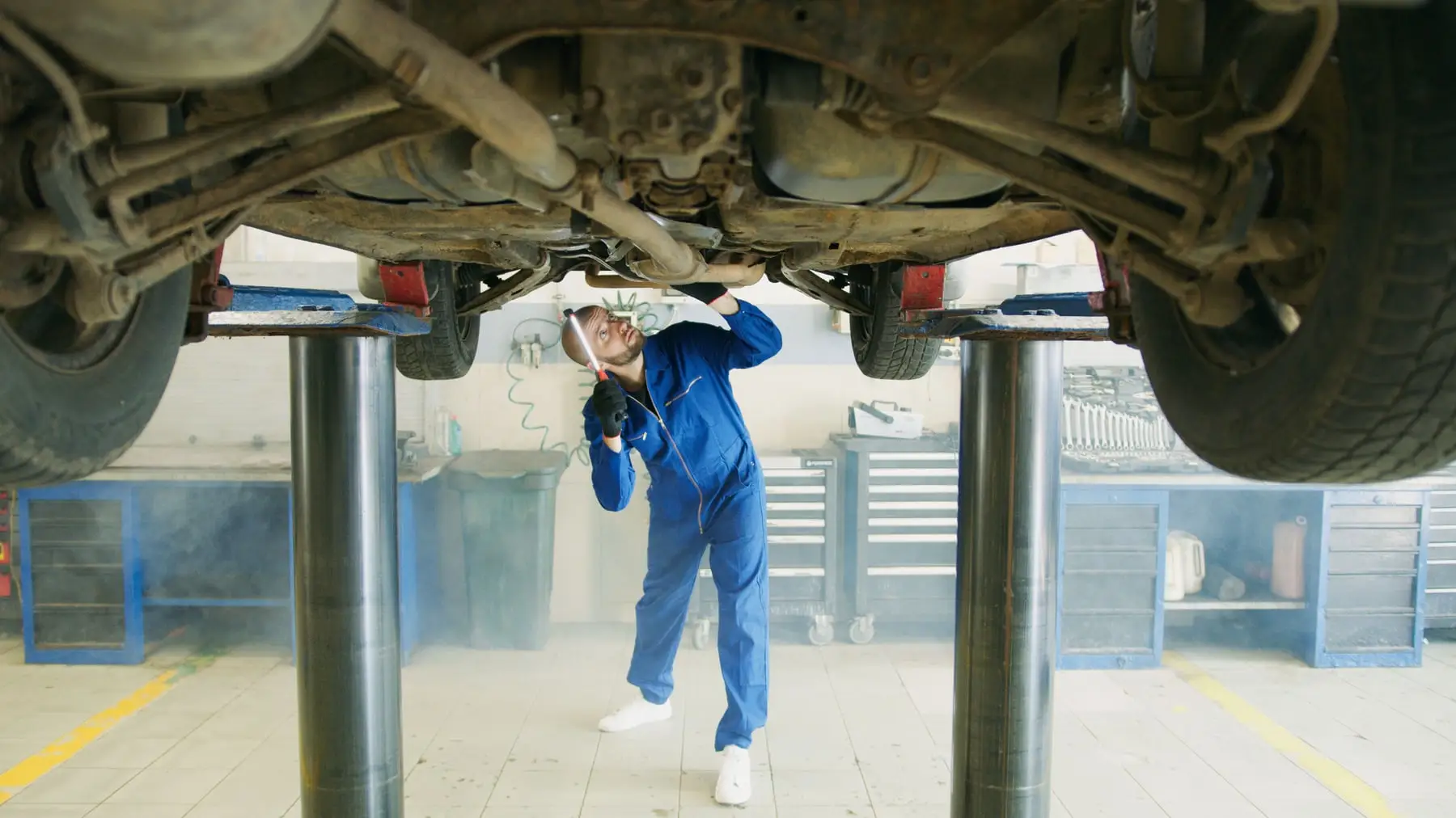 A car raised on a two post hoist with the underbody in view