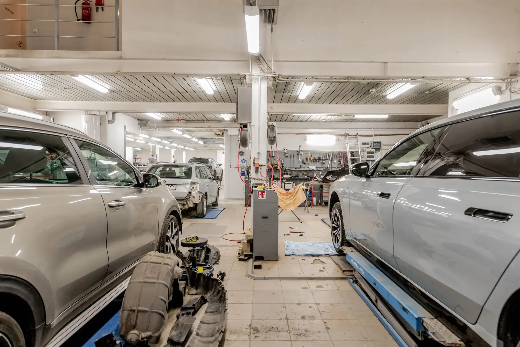 The interior of a workshop with vehicles in for servicing